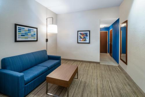 a living room with a blue couch and a table at Holiday Inn Express Hotel & Suites Talladega by IHG in Talladega
