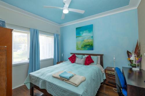 a blue bedroom with a bed and a ceiling fan at Kurranulla Sapphire - U2 in Cronulla