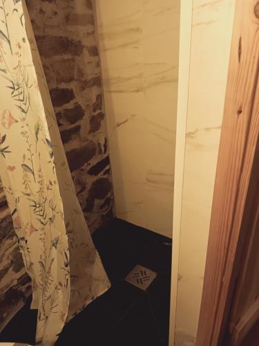 a bathroom with a shower with a stone wall at Ceira Cottage in Góis