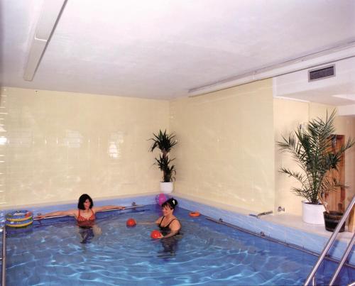 Dos mujeres están jugando en una piscina en Hotel Hasselbarth, en Burg auf Fehmarn