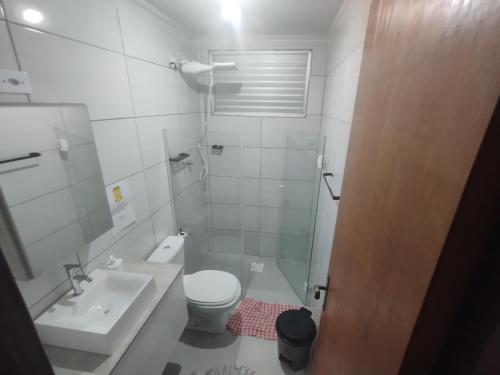 ein Badezimmer mit einem weißen WC und einem Waschbecken in der Unterkunft Apartamento em Praia Grande - Frente ao Mar in Praia Grande