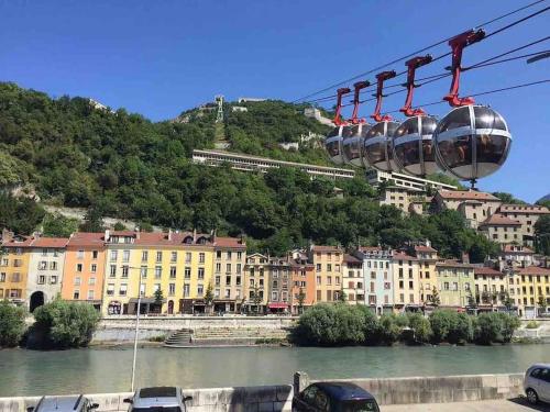 a gondola ride over a river in a city at Ô calme Cosy - Jardins et Villes - Expérience Unique - Wifi Gratuit - Parking gratuite in Grenoble