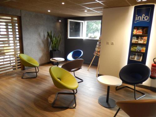 a waiting room with colorful chairs and tables at ibis Budget Pau Est in Pau