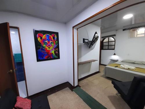 a room with a bed and a painting on the wall at GRAN APARTAESTUDIO EN BOSTON - MEDELLIN in Medellín