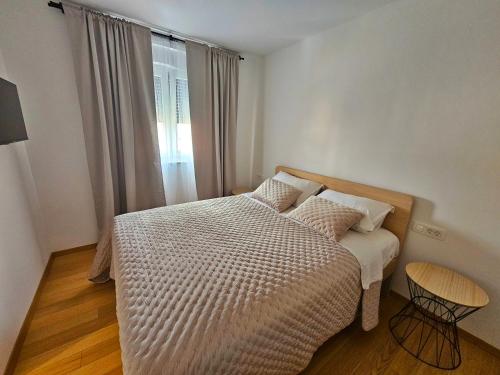 um pequeno quarto com uma cama e uma janela em Luxury Penthouse with seaview and parking em Zadar
