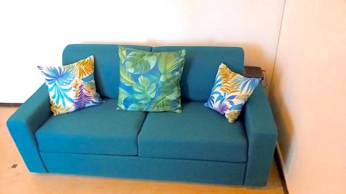 a blue couch with three pillows on it at Studio centre de Fort-de-France in Fort-de-France