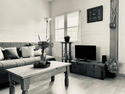 a living room with a tv and a coffee table at Le Gîte du Phare vue sur mer in Cayeux-sur-Mer