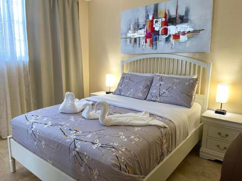 dos cisnes sentados en una cama en un dormitorio en Sunny Isles Miami HOLIDAY apartment, en Miami Beach