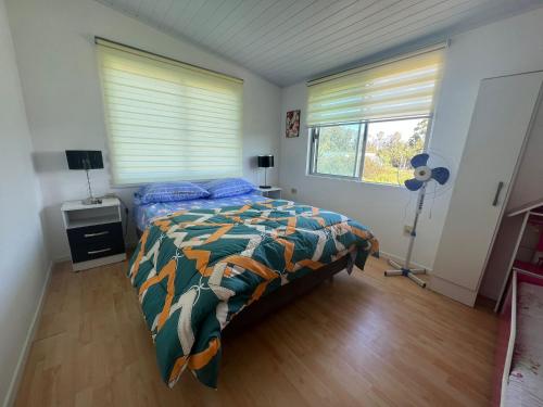 a bedroom with a bed and a fan in it at Casa shalet completa para 6 personas in Bella Vista