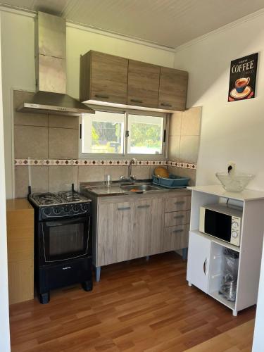a small kitchen with a stove and a microwave at Casa shalet completa para 6 personas in Bella Vista