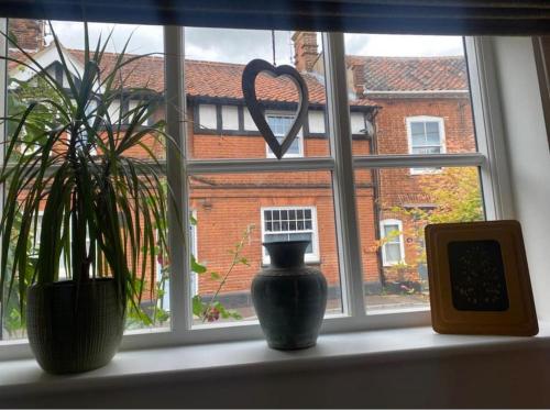 a window with two vases sitting on a window sill at The Town House in Aylsham
