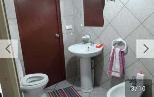 a bathroom with a toilet and a sink at Chez Guy , chambre privée in Tiputa
