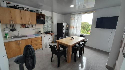 a kitchen with a wooden table and black chairs at Apto Hogar Dulce Hogar ARBOLETES in Arboletes