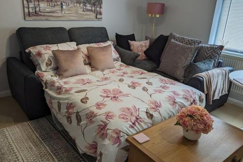 a living room with a couch with a flowered blanket at Turtle Dove Apartment in Oxford