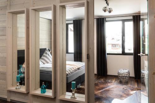 奧伯斯特多夫的住宿－奧伯斯特多夫N6公寓，一间卧室设有三扇玻璃门,内配一张床