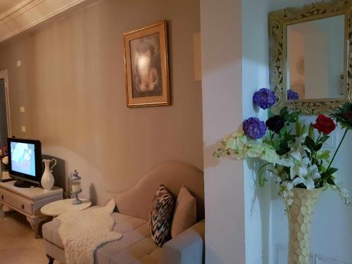 una sala de estar con sofá y un jarrón de flores en Appartement luxueux au bord de la mer, en Nabeul