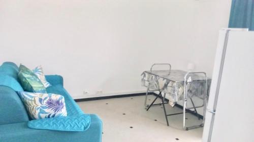 a living room with a blue couch and a table at Studio centre de Fort-de-France in Fort-de-France
