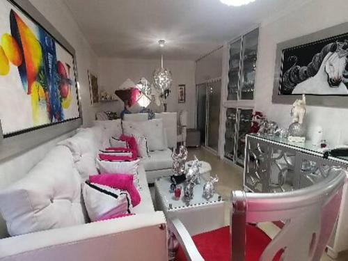 sala de estar con sofás blancos y detalles en color rosa en Apartamento K de 3 a 5 Minutos de la embajada, en Pantoja