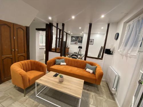 a living room with a couch and a table at La galerie, proche aéroport in Tillé