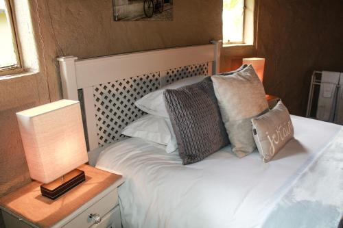 a bedroom with a white bed with pillows on it at Siesta Guesthouse & Wedding Venue - Frankfort in Frankfort