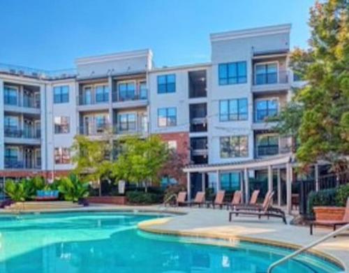 an apartment complex with a swimming pool in front of a building at Luxury at Perimeter Gardens. in Dunwoody