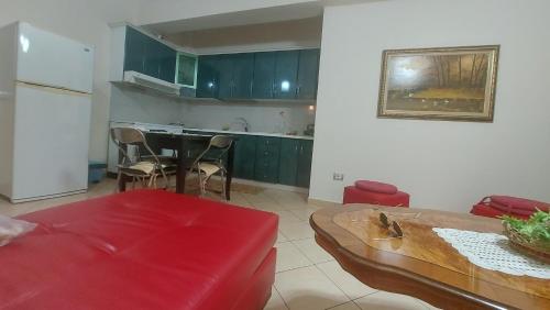 a living room with a red couch and a kitchen at Apartment Juri in Vlorë