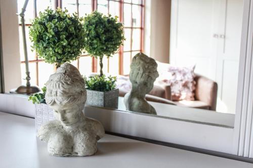 a table with two statues sitting in front of a mirror at Siesta Guesthouse & Wedding Venue - Frankfort in Frankfort