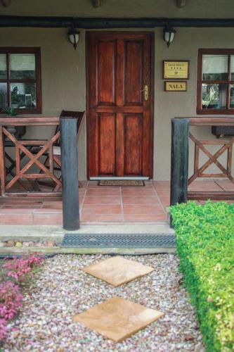a house with a wooden door and a patio at Siesta Guesthouse & Wedding Venue - Frankfort in Frankfort