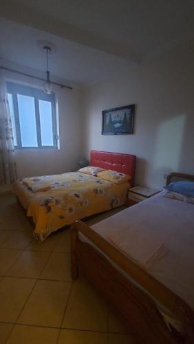 a bedroom with two beds and a window at Apartment Juri in Vlorë