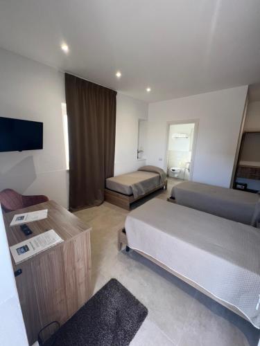 een hotelkamer met 2 bedden en een flatscreen-tv bij PoolSide in Irsina