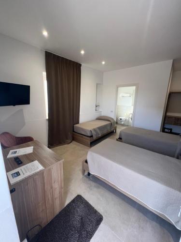 a hotel room with two beds and a flat screen tv at PoolSide in Irsina