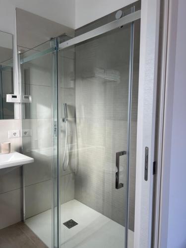 een glazen douche in een badkamer met een wastafel bij PoolSide in Irsina