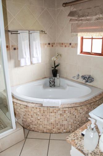 a bath tub in a bathroom with a window at Siesta Guesthouse & Wedding Venue - Frankfort in Frankfort