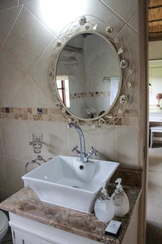 a bathroom with a sink and a mirror at Siesta Guesthouse & Wedding Venue - Frankfort in Frankfort