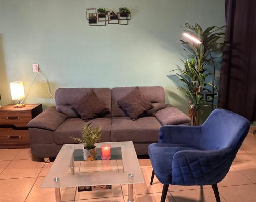a living room with a couch and a blue chair and a table at Brisa del Mar #6 in Brisas de Zicatela