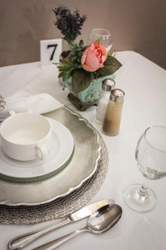 a table with a plate and a cup and saucer on it at Siesta Guesthouse & Wedding Venue - Frankfort in Frankfort