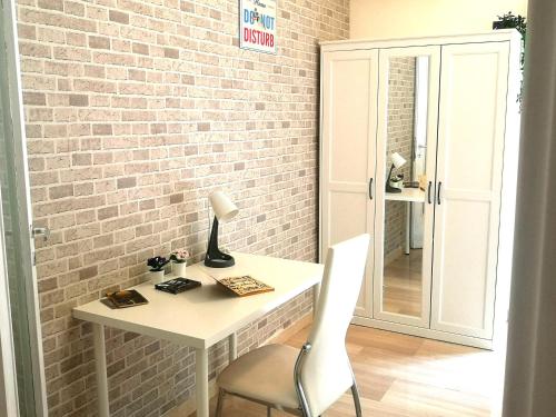 białe biurko z krzesłem obok ściany z cegły w obiekcie DREAMS APARTMENT w Rzymie