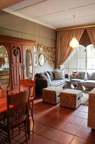 a living room with a couch and a table at Siesta Guesthouse & Wedding Venue - Frankfort in Frankfort