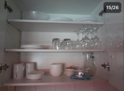 a shelf filled with glasses and plates and bowls at Cabañas del Puerto in Puerto Montt