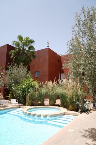 une piscine en face d'un bâtiment dans l'établissement MORO Marrakech Boutique Hôtel, à Marrakech