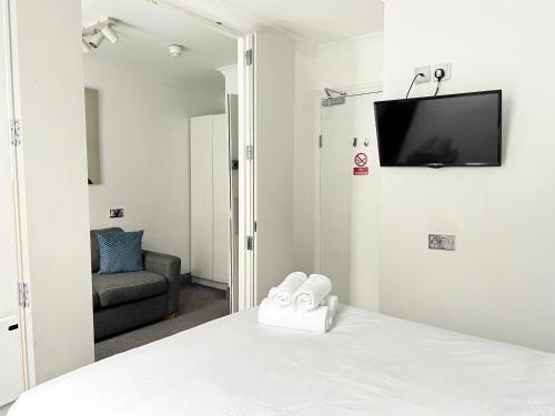 a bedroom with a bed with a tv on the wall at The Dome in London