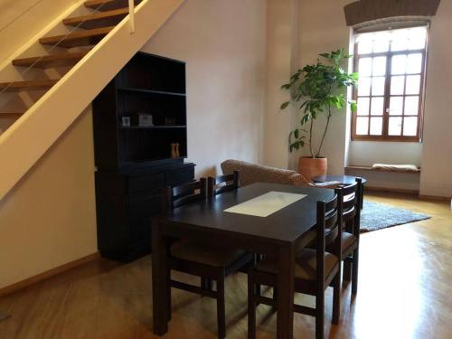 een eetkamer met een tafel en stoelen en een trap bij Loft in Quito's historic center in Quito