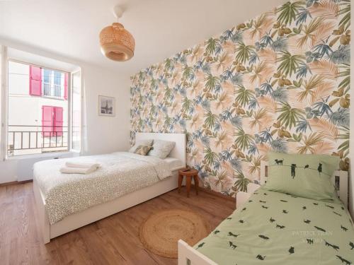 a bedroom with a bed and a tropical wallpaper at Appartement pour 8 personnes près de Disney & Paris in Chanteloup-en-Brie