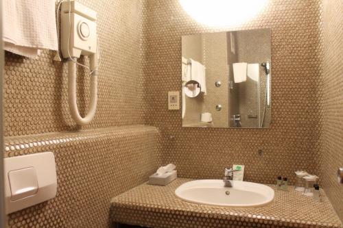 a bathroom with a sink and a mirror at Steichele Hotel & Weinrestaurant in Nuremberg