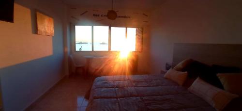 1 dormitorio con 1 cama frente a una ventana en Amar el mar en Puerto Madryn