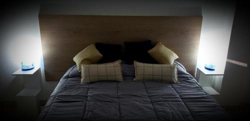Un dormitorio con una cama con dos luces. en Amar el mar en Puerto Madryn