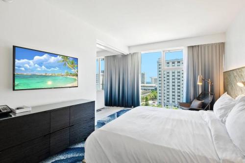 a hotel room with a large bed and a large window at Oceanview Luxury, Resort Access, Sleeps 6 2BR 2BA - Vista Mar by HomeStakes in Fort Lauderdale