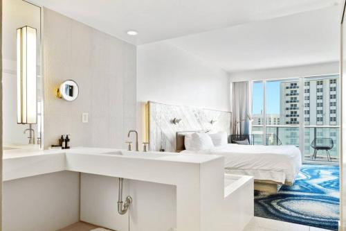 Baño blanco con cama y lavabo en Oceanview Luxury, Resort Access, Sleeps 6 2BR 2BA - Vista Mar by HomeStakes, en Fort Lauderdale