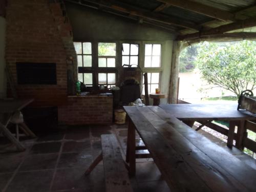 una gran mesa de madera en una habitación con chimenea en Sítio lageana, en Gramado