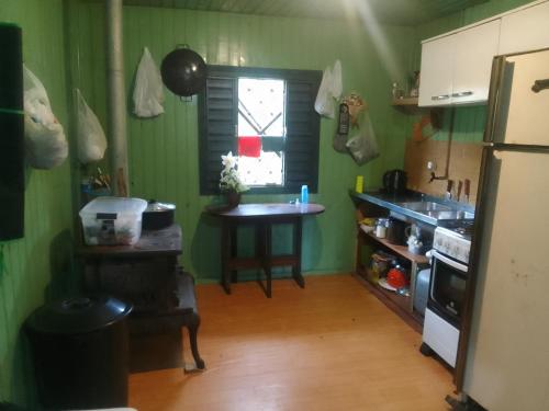 kuchnia ze zlewem, stołem i oknem w obiekcie Sítio lageana w mieście Gramado